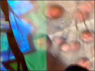 Psychedelisch angehauchtes Bild mit orangfarbenen Kreisen auf hellem Grund und blauen und grünen Elementen links außen